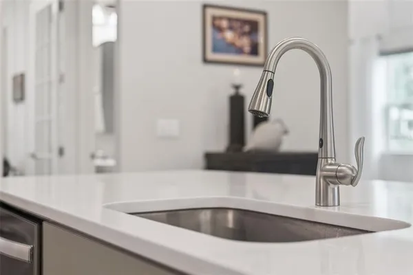 a kitchen with stainless steel appliances a sink a stove a microwave a refrigerator and cabinets