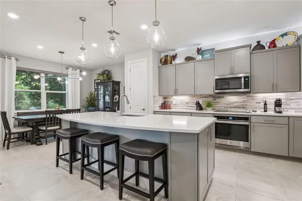 a kitchen with kitchen island stainless steel appliances a stove sink and microwave