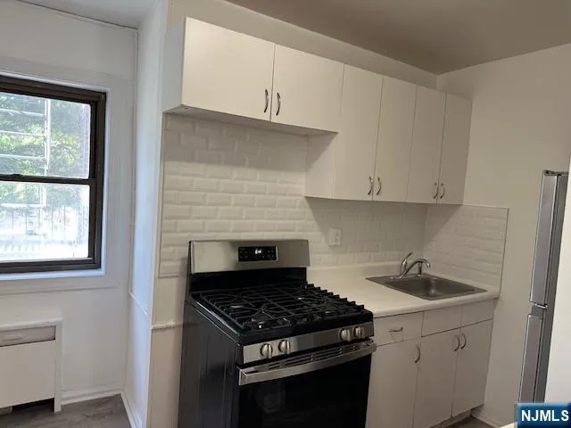 a kitchen with white cabinets and appliances