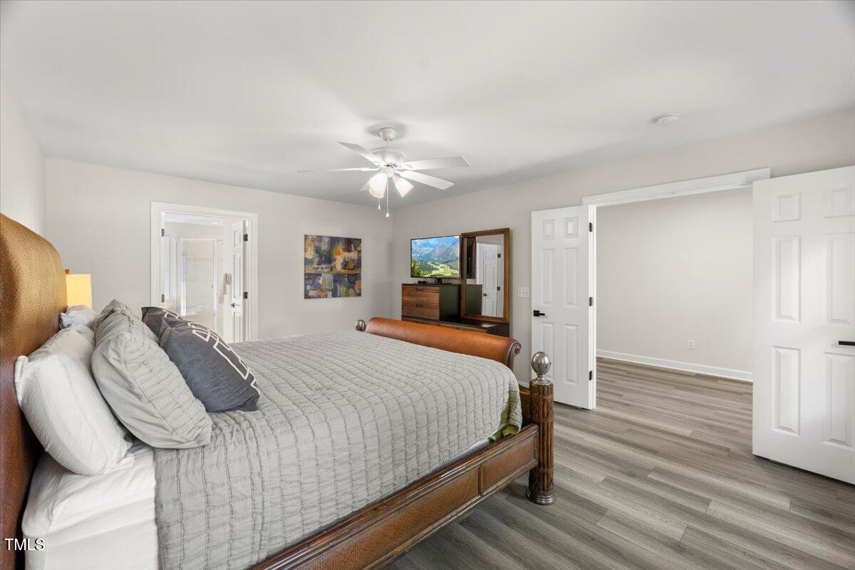 1404 Kings Lassiter Way Raleigh, NC 27614 - Photo 15 of 28 a bedroom with a bed and a chandelier