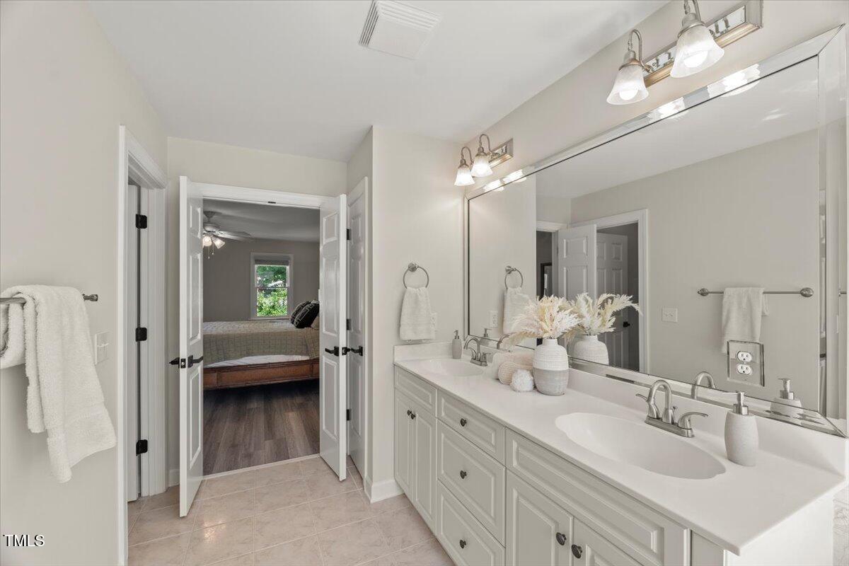 1404 Kings Lassiter Way Raleigh, NC 27614 - Photo 18 of 28 a bathroom with a double vanity sink and a mirror