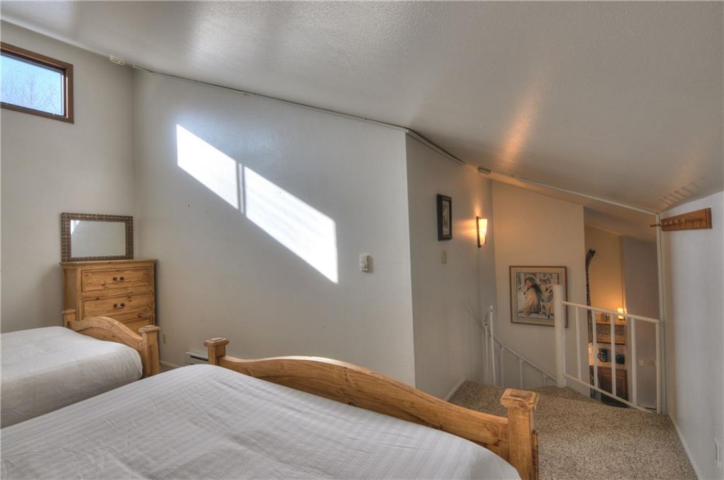 1977 Soda Ridge Road, Unit 1218 Keystone, CO 80435 - Photo 13 of 23 a bedroom with a bed and wooden floor