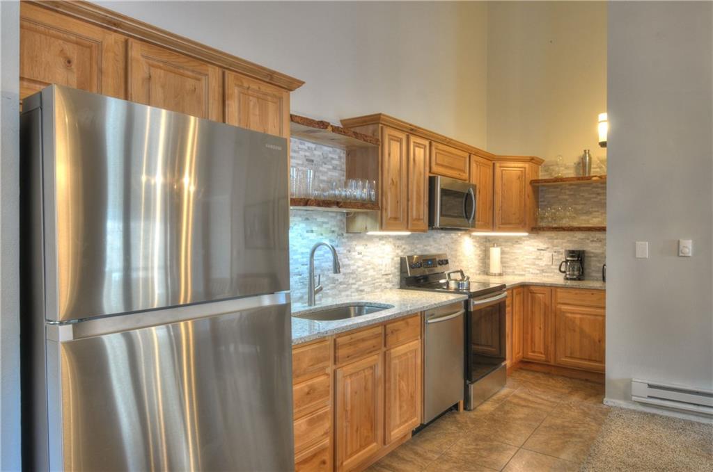 1977 Soda Ridge Road, Unit 1218 Keystone, CO 80435 - Photo 5 of 23 a kitchen with stainless steel appliances granite countertop a refrigerator and a sink