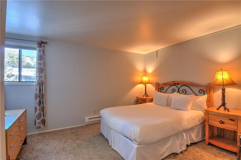1977 Soda Ridge Road, Unit 1218 Keystone, CO 80435 - Photo 8 of 23 a bedroom with a bed and lamp with window