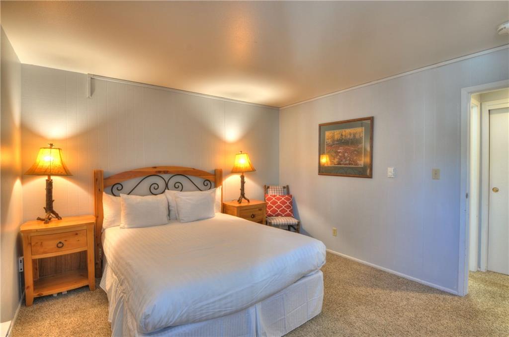 1977 Soda Ridge Road, Unit 1218 Keystone, CO 80435 - Photo 9 of 23 a bedroom with a bed and a night stand