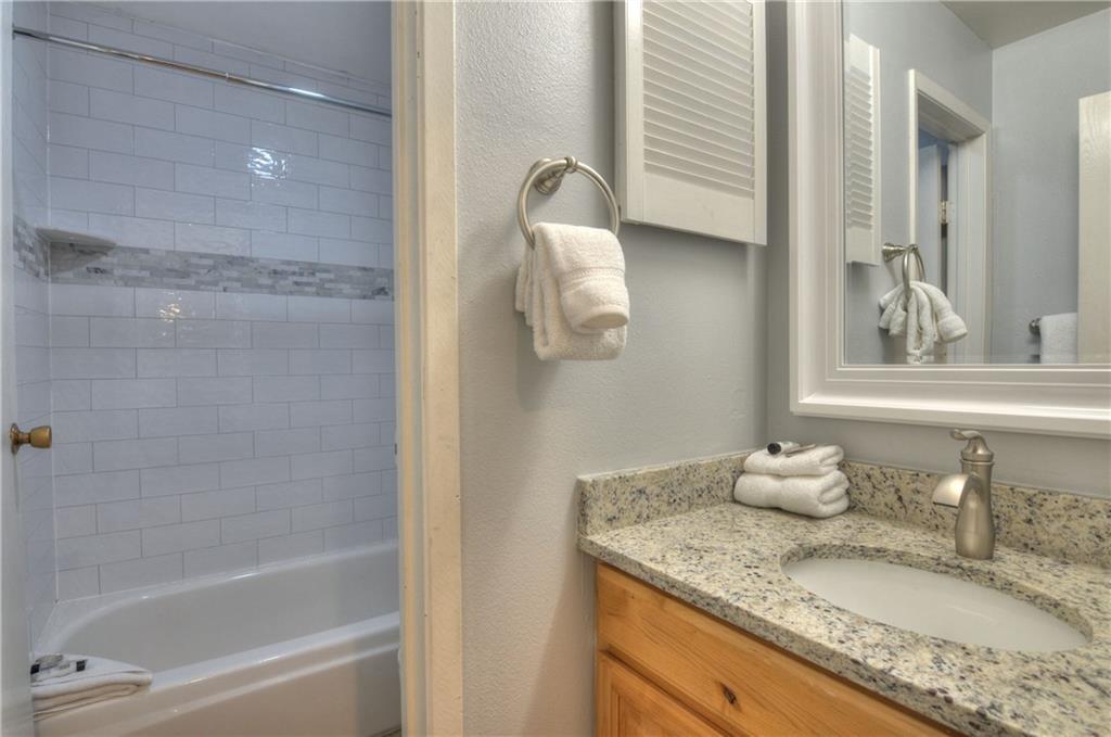 1977 Soda Ridge Road, Unit 1218 Keystone, CO 80435 - Photo 10 of 23 a bathroom with a granite countertop sink and a mirror