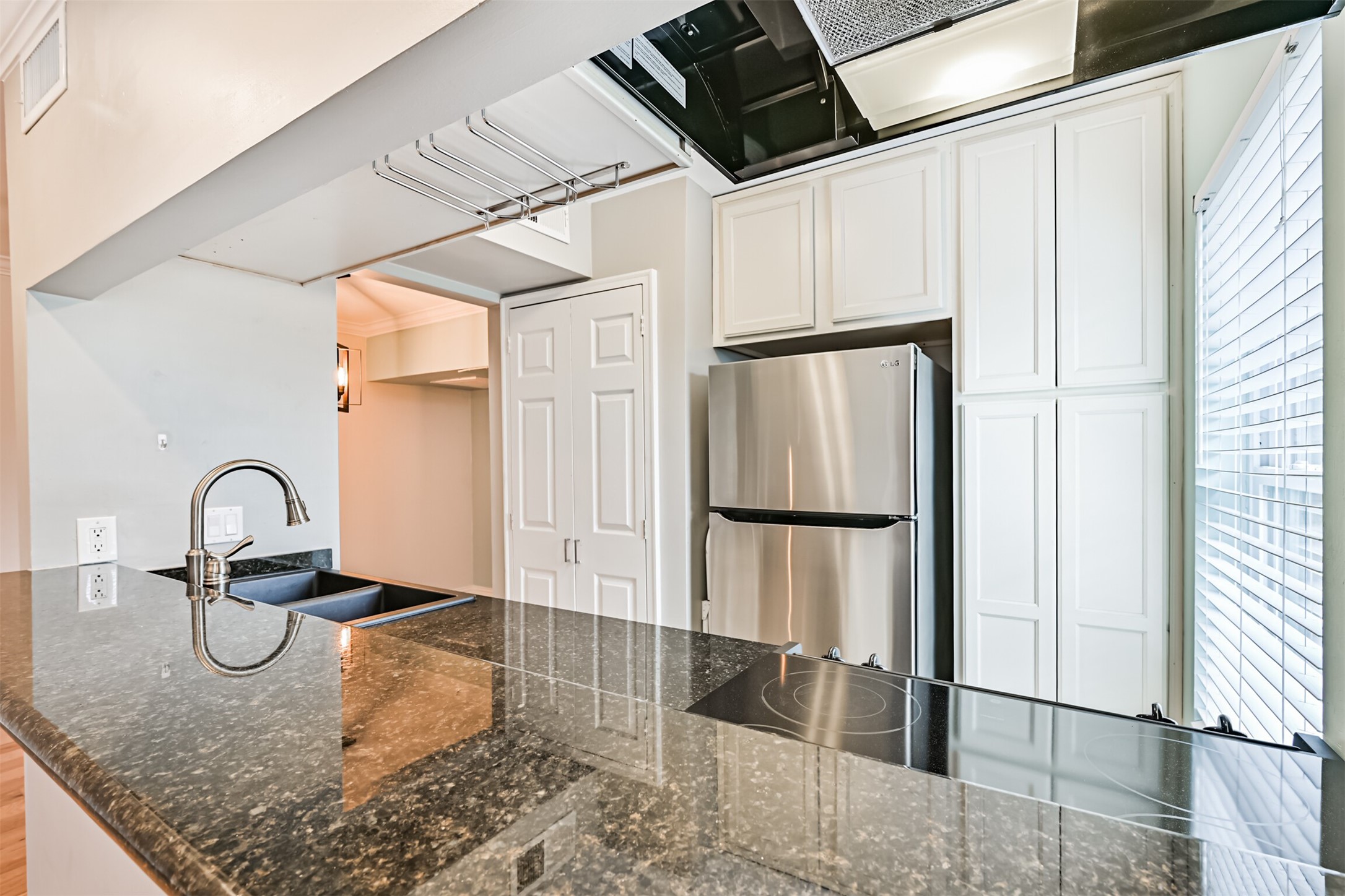402 Postoffice Street, Unit 201 Galveston, TX 77550 - Photo 16 of 29 a kitchen with granite countertop a refrigerator and white cabinets