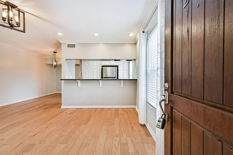 a view of a kitchen with wooden floor and electronic appliances