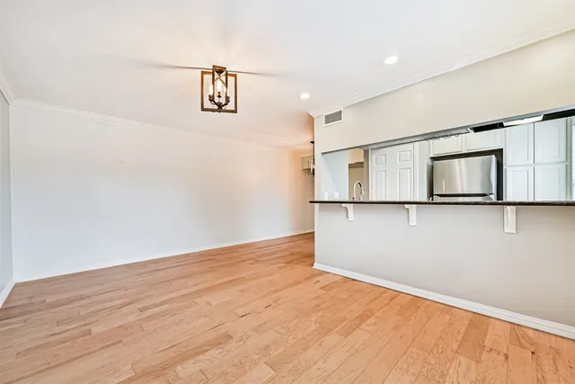 a view of empty room with wooden floor