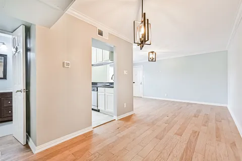 a view of empty room with wooden floor and window