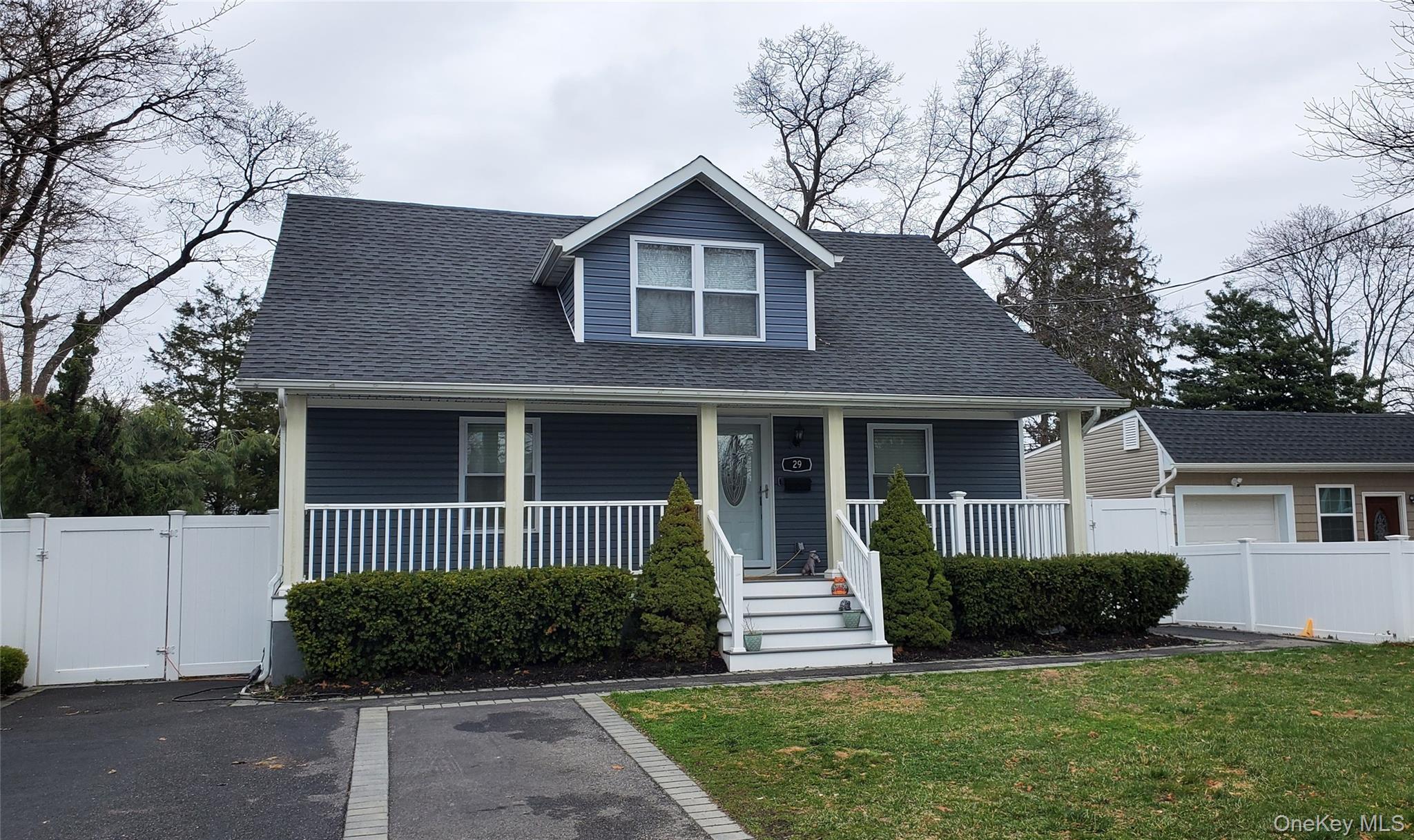 Bungalow-style house with a gate, covered porch, and roof with shingles