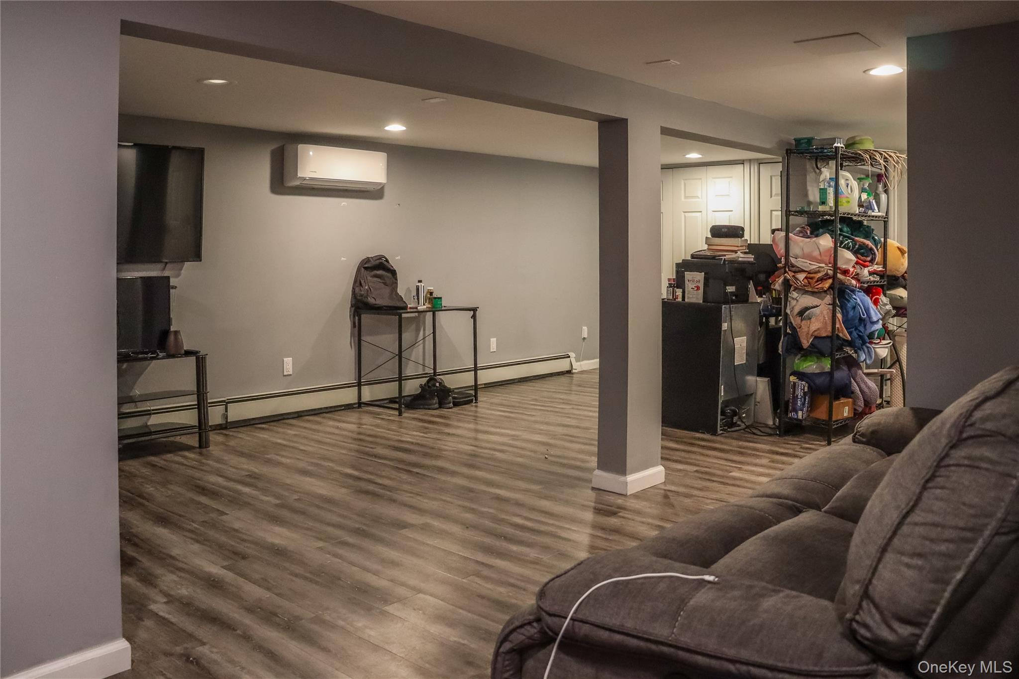 29 Oak Street Islip, NY 11751 - Photo 11 of 15 Living area featuring wood finished floors, recessed lighting, a baseboard heating unit, and a wall mounted AC