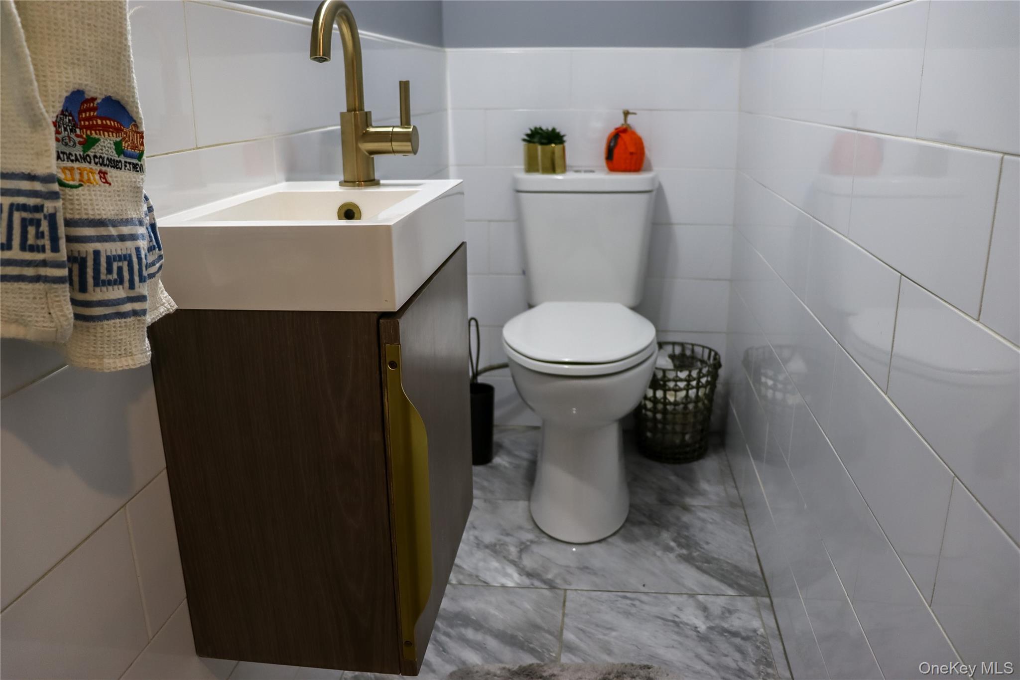 29 Oak Street Islip, NY 11751 - Photo 6 of 15 Bathroom featuring tile walls, vanity, and light tile patterned floors