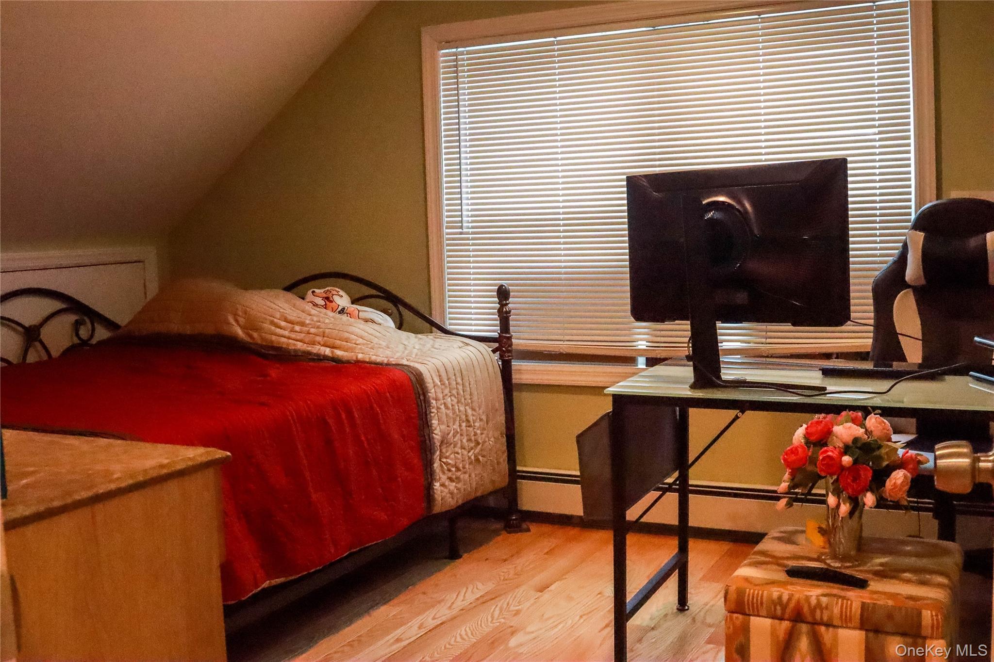 29 Oak Street Islip, NY 11751 - Photo 7 of 15 Bedroom with vaulted ceiling, light wood-type flooring, and a baseboard radiator