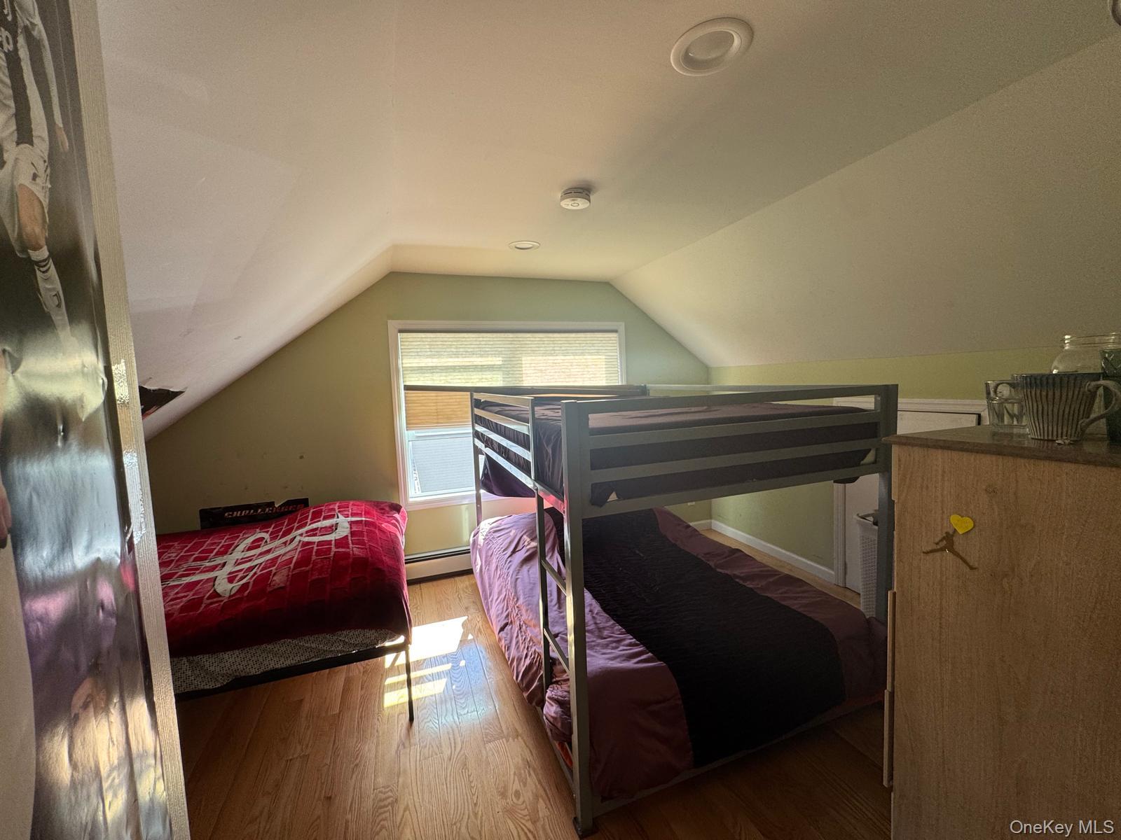 29 Oak Street Islip, NY 11751 - Photo 9 of 15 Bedroom featuring light wood-style floors, lofted ceiling, and baseboard heating
