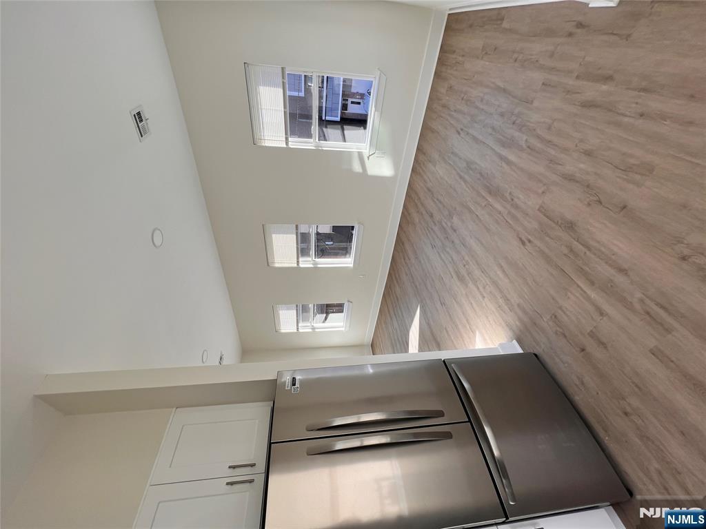 a view of a refrigerator in kitchen and wooden floor