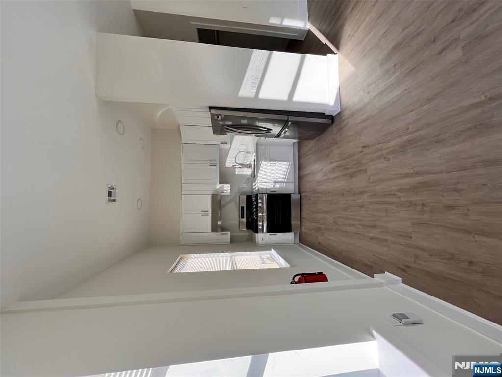 70 69th Street, Unit 4 Guttenberg, NJ 07093 - Photo 2 of 4 a living room with stainless steel appliances furniture a refrigerator and a fireplace