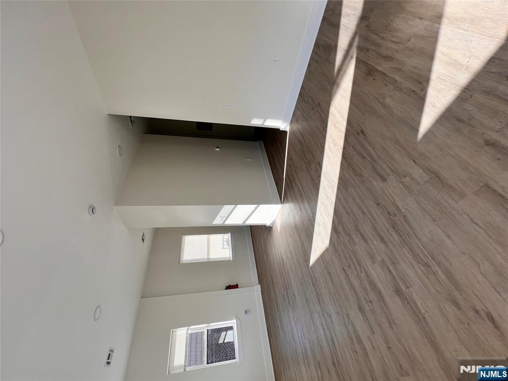 70 69th Street, Unit 4 Guttenberg, NJ 07093 - Photo 3 of 4 a view of an empty room with wooden floor and a window