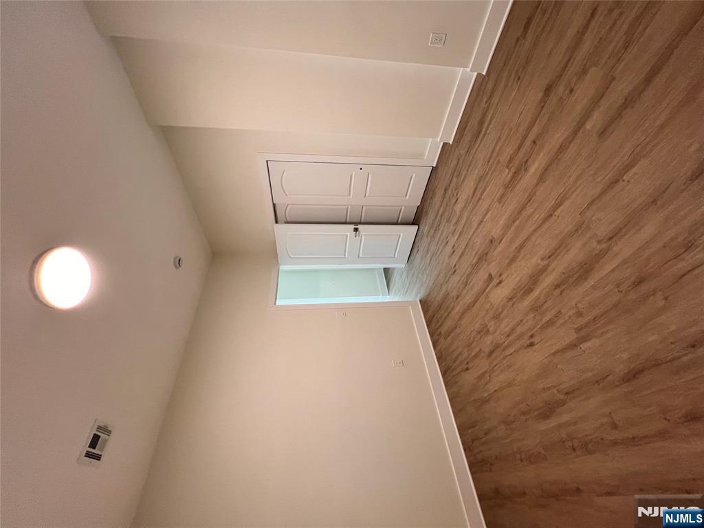 70 69th Street, Unit 4 Guttenberg, NJ 07093 - Photo 4 of 4 a view of an empty room with wooden floor and a window