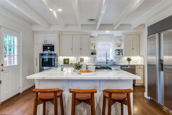 a kitchen with a table chairs refrigerator and cabinets