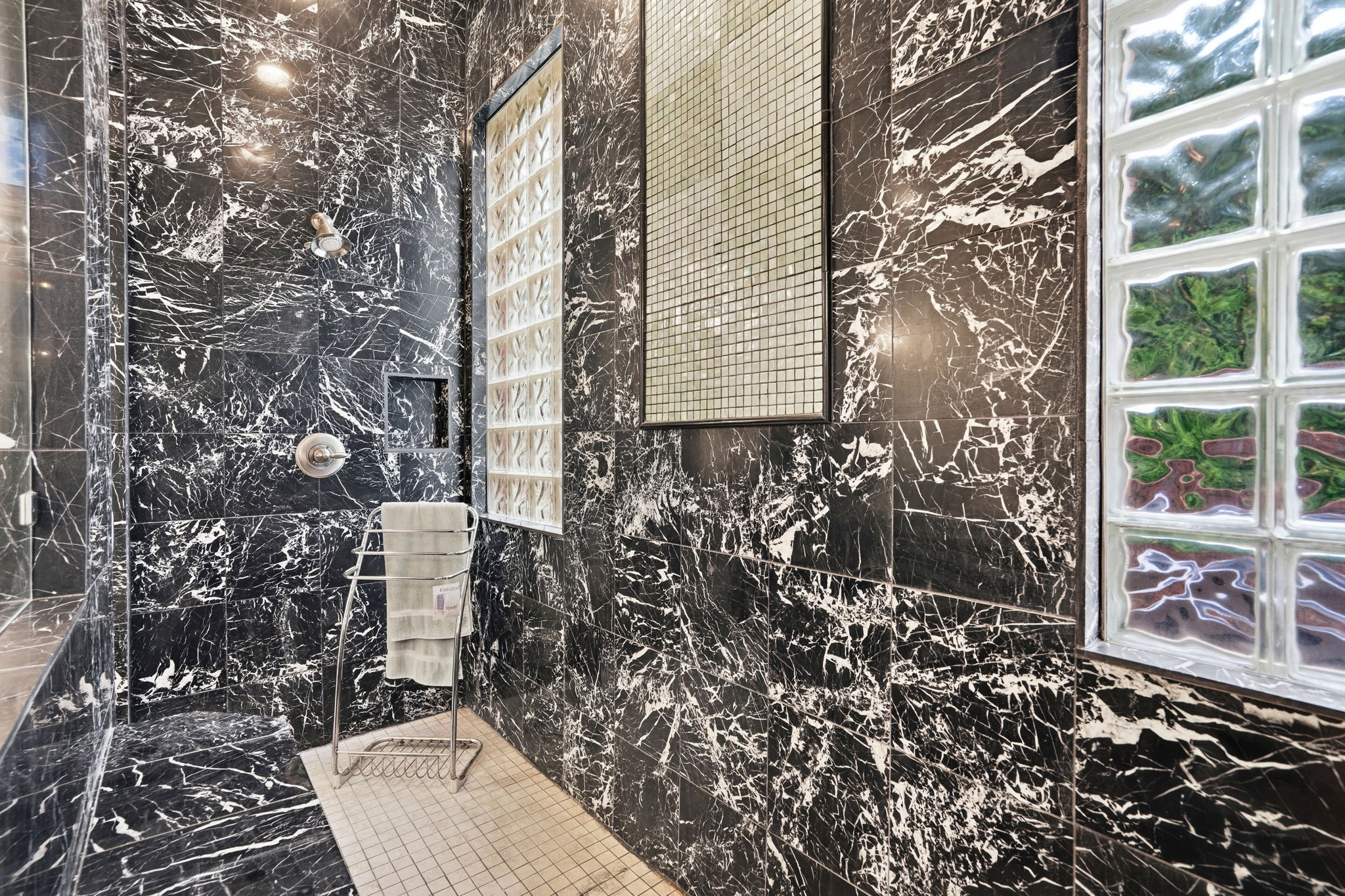 222 Vailco Lane Austin, TX 78738 - Photo 36 of 39 Shower with black stone-finish walls, a built-in shower niche, and a tiled floor