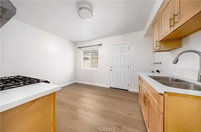 a kitchen with a sink a stove and cabinets