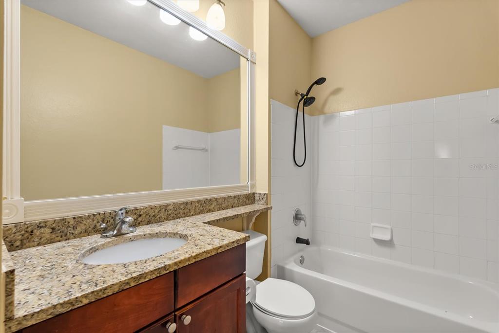 126 Vista Verdi Circle, Unit 108 Lake Mary, FL 32746 - Photo 11 of 20 a bathroom with a granite countertop sink and a mirror