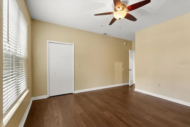 a spacious bathroom with a granite countertop sink a toilet a mirror and bathtub