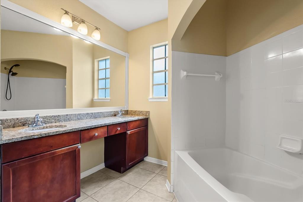 126 Vista Verdi Circle, Unit 108 Lake Mary, FL 32746 - Photo 14 of 20 a spacious bathroom with a granite countertop sink a toilet a mirror and bathtub