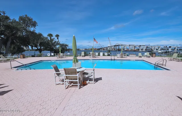a swimming pool with outdoor seating and yard