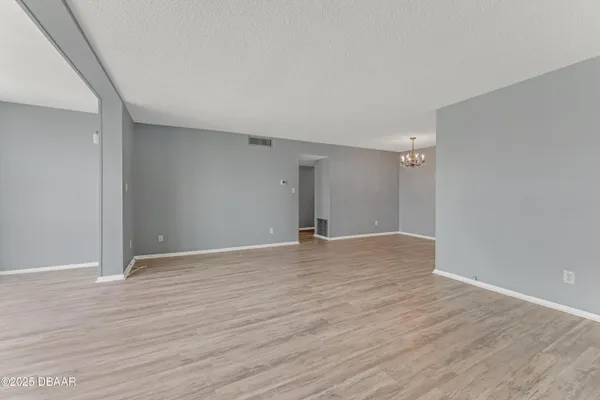 a view of an empty room with wooden floor
