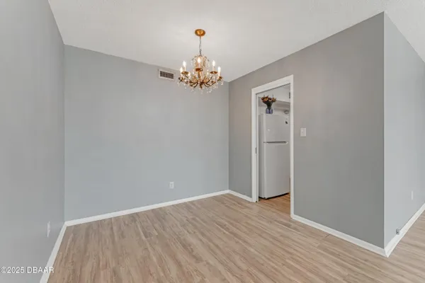 a view of room with wooden floor and chandelier