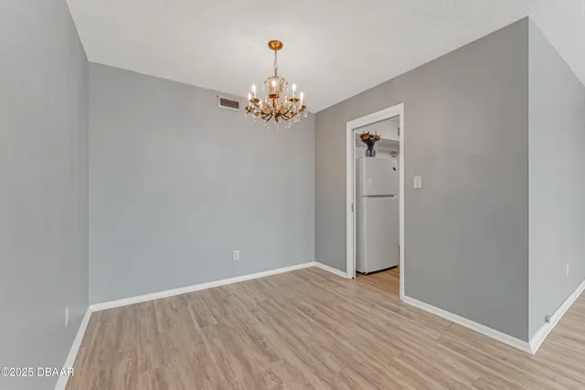 a view of room with wooden floor and chandelier