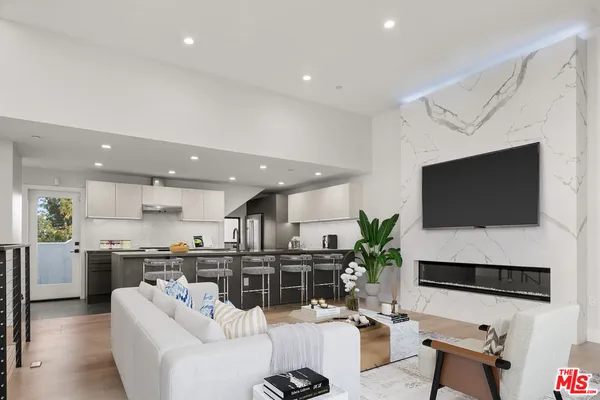 a living room with stainless steel appliances a flat screen tv and a living room view