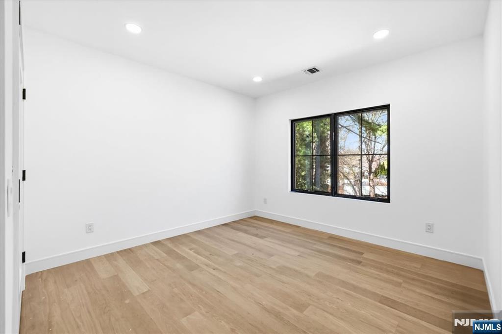 150 Howland Avenue River Edge, NJ 07661 - Photo 23 of 45 an empty room with wooden floor and windows