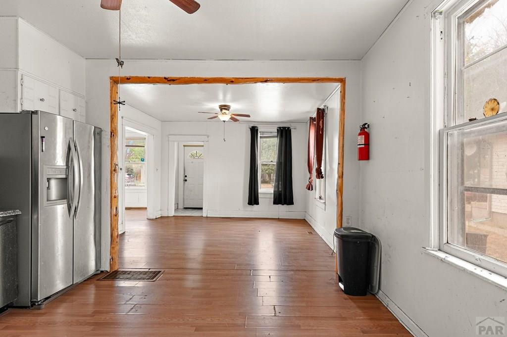 405 7th Street Fowler, CO 81039 - Photo 8 of 25 a view of a refrigerator in kitchen and an empty room with wooden floor windows