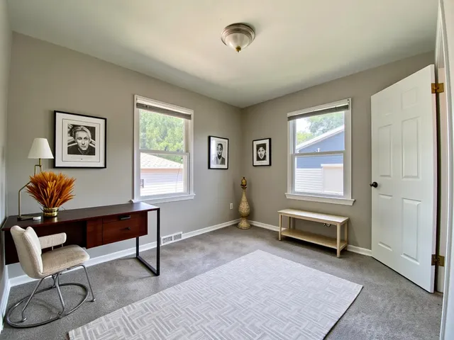 a view of a workspace with furniture and a window