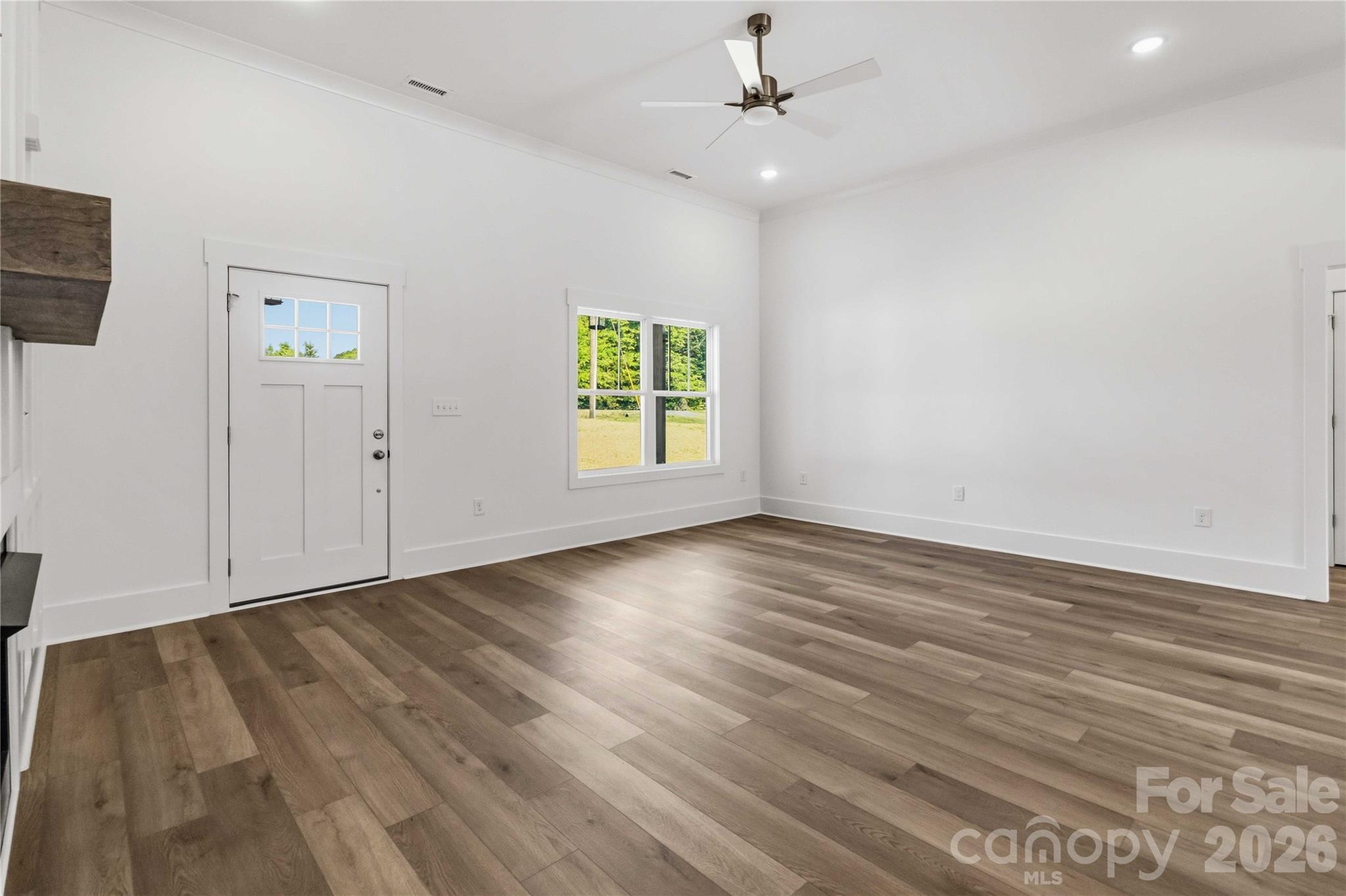 352 Adams Road Clover, SC 29710 - Photo 6 of 38 an empty room with wooden floor chandelier fan and windows