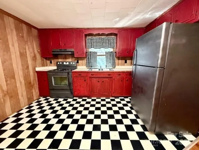 a kitchen with stainless steel appliances granite countertop a refrigerator and a stove