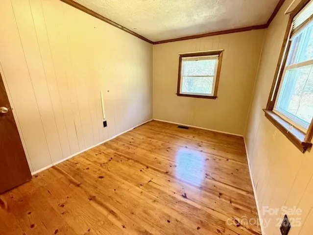 a view of a big room with wooden floor and windows
