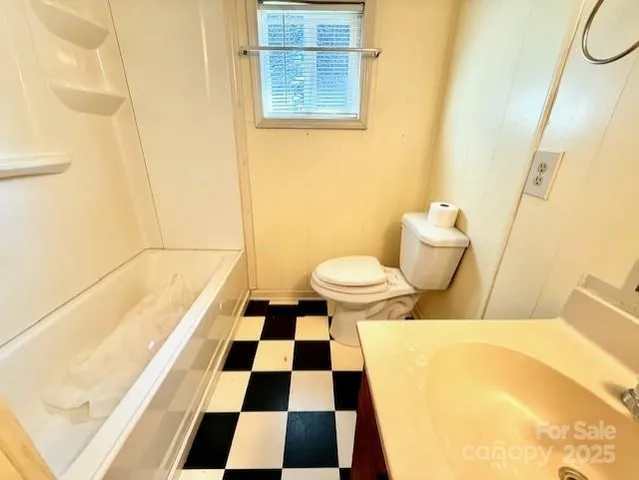 a bathroom with a black and white checkered floor