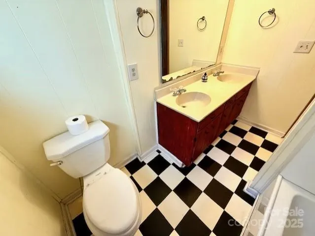 a bathroom with a sink mirror vanity and toilet
