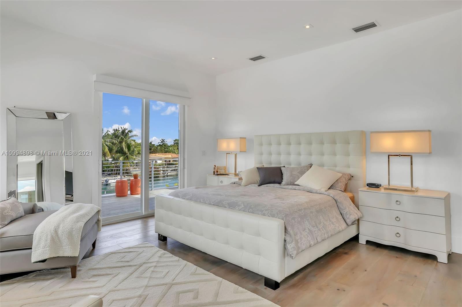 12565 Palm Road North Miami, FL 33181 - Photo 38 of 75 a bedroom with a bed and a lamp on table