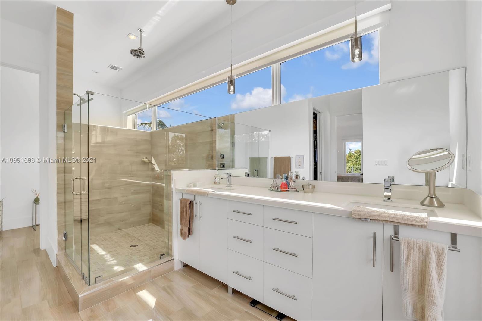 12565 Palm Road North Miami, FL 33181 - Photo 45 of 75 a bathroom with a double vanity sink mirror and shower