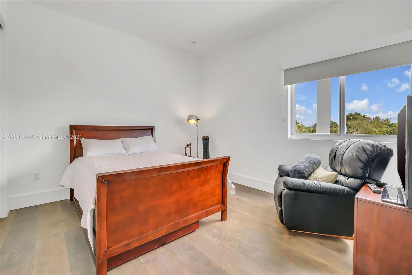 12565 Palm Road North Miami, FL 33181 - Photo 51 of 75 a bedroom with furniture and a large window