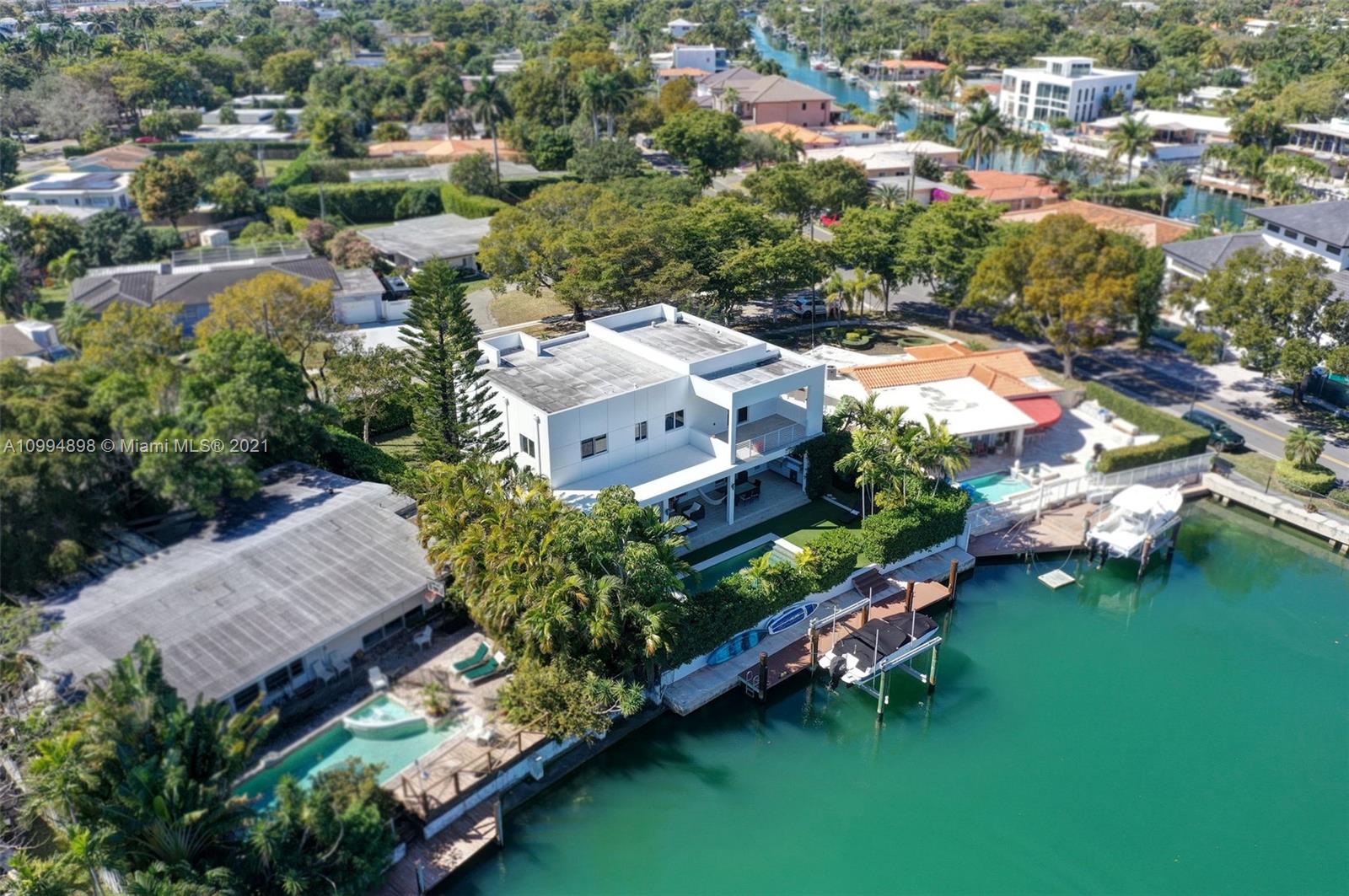12565 Palm Road North Miami, FL 33181 - Photo 60 of 75 an aerial view of a house with a garden and lake view