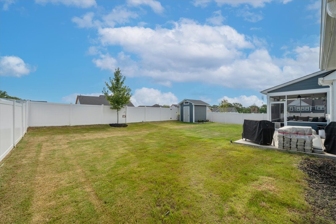 621 Wh Kay Lane Anderson, SC 29621 - Photo 41 of 50 A spacious backyard with verdant lawn and a charming HE-SHE SHED provides generous outdoor living space.