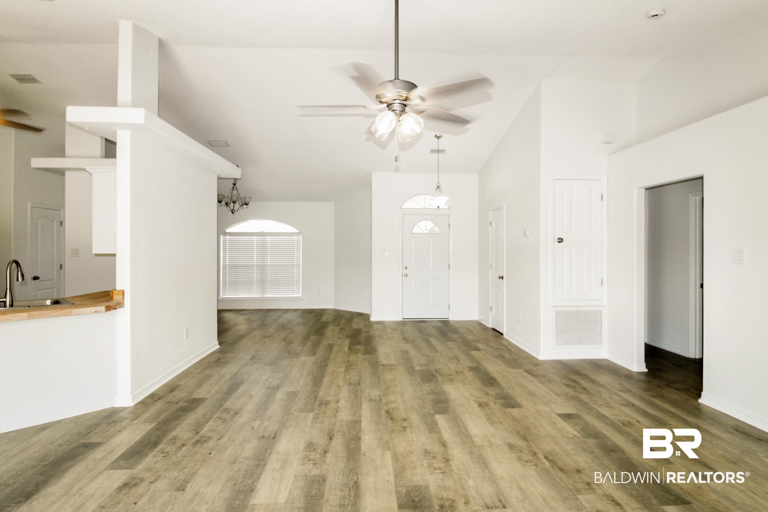 14750 Pawnee Court Foley, AL 36535 - Photo 16 of 34 Unfurnished living room featuring ceiling fan, wood finished floors, high vaulted ceiling, and a chandelier