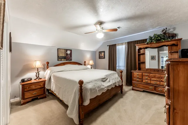 a spacious bedroom with a bed and a chandelier