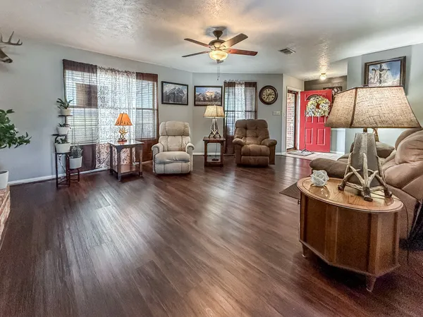 a living room with furniture and a wooden floor